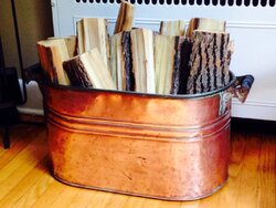 Antique copper tub for hearthside wood storage.
