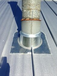 Stove pipe flashing on corrugated metal roof.