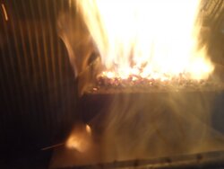 Fire behind the burn pot of a Harman Accentra FS...