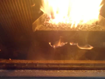 [Hearth.com] Fire behind the burn pot of a Harman Accentra FS...