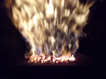 [Hearth.com] Fire behind the burn pot of a Harman Accentra FS...