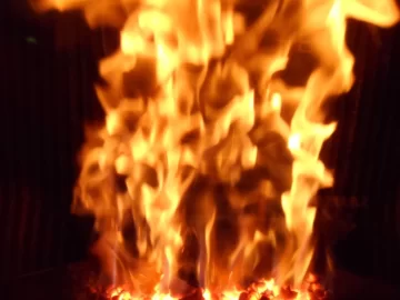 [Hearth.com] Fire behind the burn pot of a Harman Accentra FS...