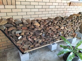 Diy firewood storage using bricks and fence pairings treated with arson