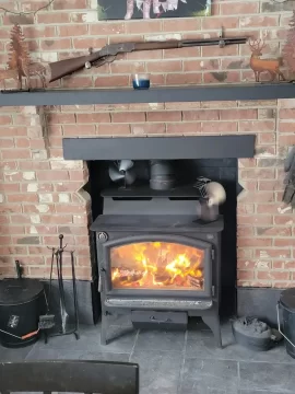 Would slate tiles on wall be a good idea even if recommended clearance behind stove is met?