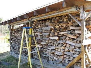 [Hearth.com] Shelter sides rolled up, wood stash revealed..