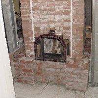 Inside core build w. refractory brick. Door was salvaged from Fireplace insert and had brackets attached to mount it within the brick work.